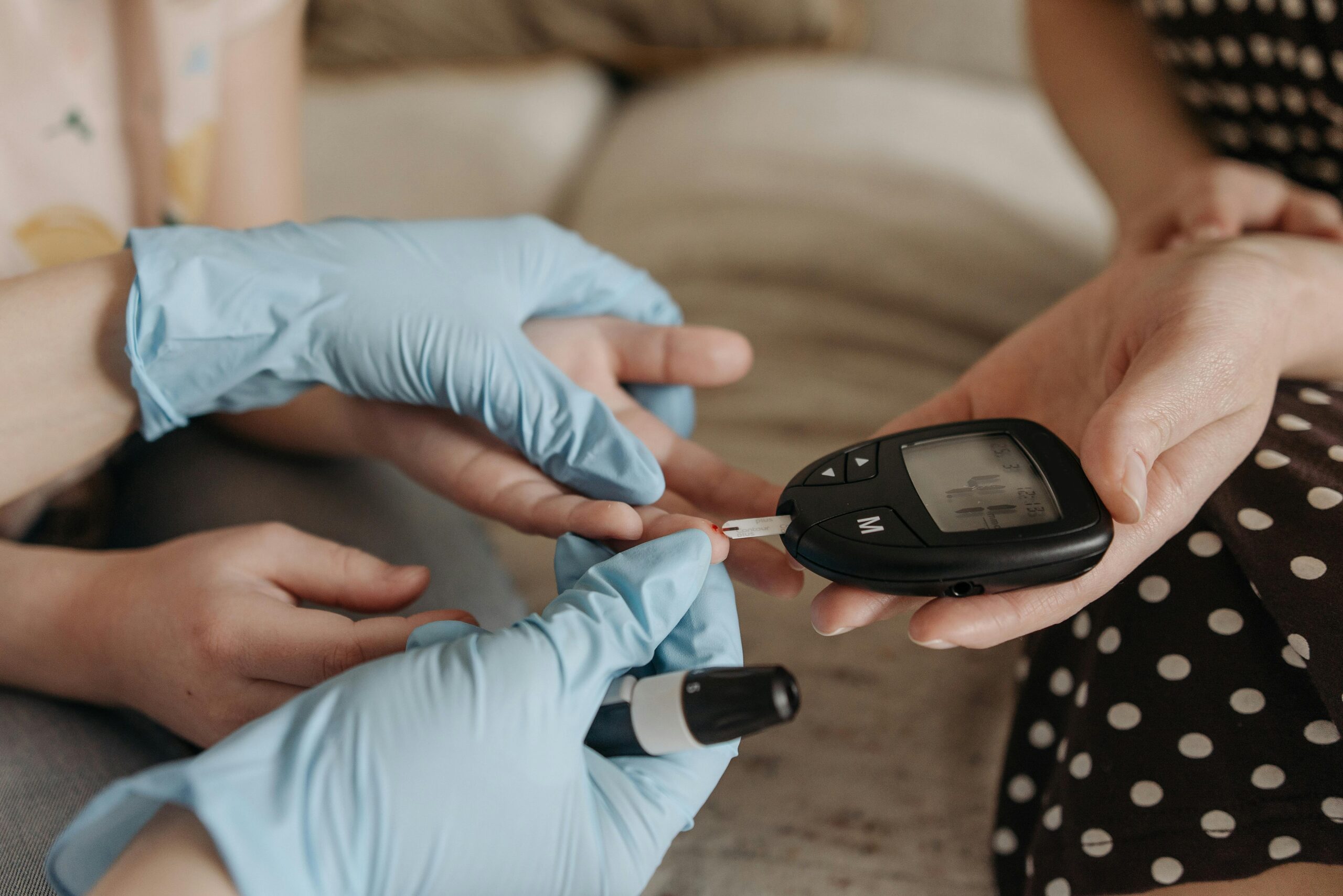 Hands measuring blood glucose levels with a glucose meter and test strip.